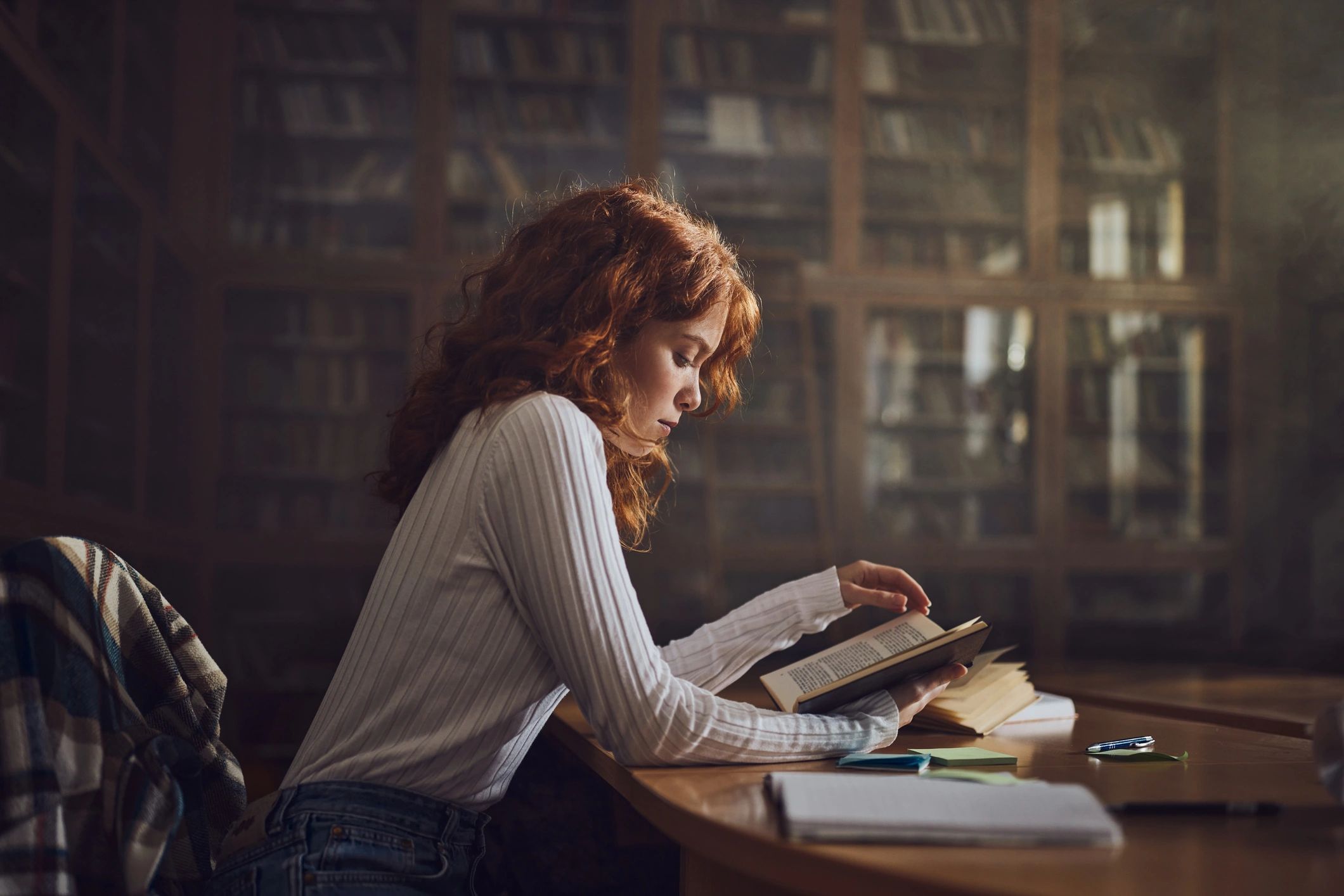 Student reading a medical textbook in a library